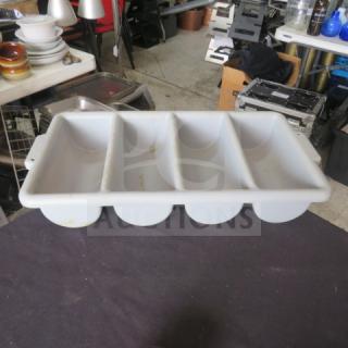 White plastic flatware holder, four compartments, visible wear and stains, rectangular shape, used condition.
