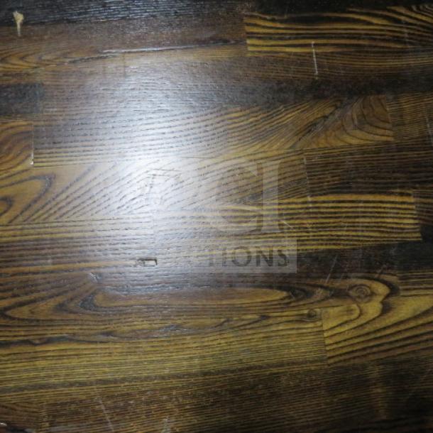 Butcher block table top with distinct wood grain pattern, 24x24 inches; pedestal base not visible. Good condition.