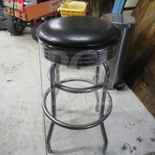 Black cushioned bar stool with two chrome rings, in good condition.