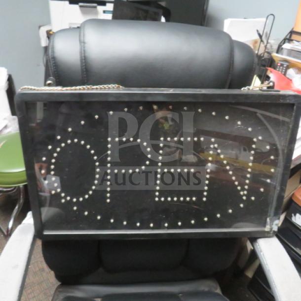 Open lighted sign, 21.5x13 inches, black frame, no plug, hangs with a chain. Good condition.