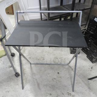 Foldable metal and pressboard table, 25x18x31 inches, black top, lightweight frame, good condition, ideal for compact spaces.