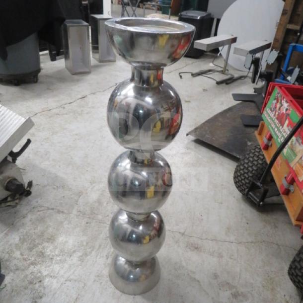 Tall silver decorative candle holder with reflective surface and sleek, stacked sphere design. Polished finish, excellent condition.