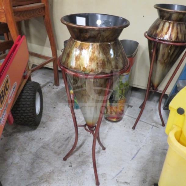 Decorative plant holder and stand, metallic finish, conical shape, tripod base, rustic brown tones, good condition.