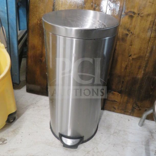 Stainless steel step trash can, cylindrical design, foot pedal, minor scuff marks, good condition.