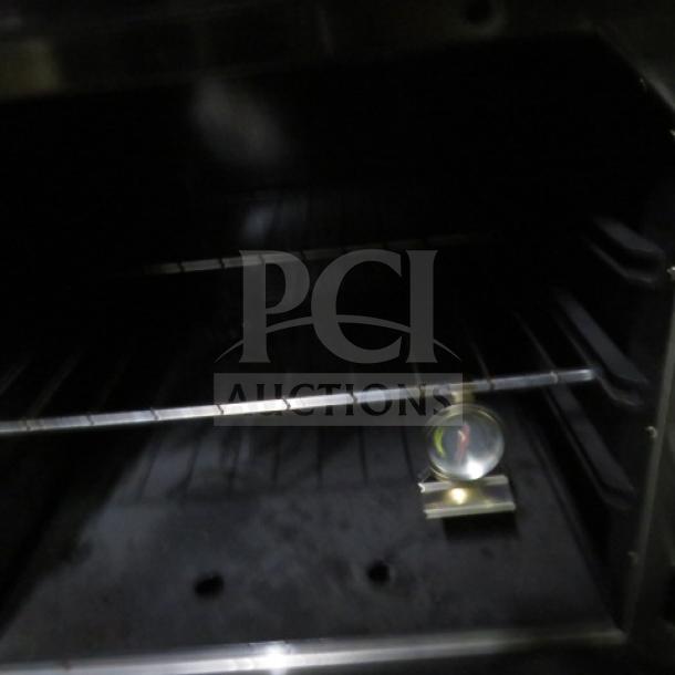 Sierra SR6B24G60 gas range oven interior with rack and thermometer. Model features 6 burners and griddle, dimensions 60"x32"x40".