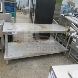 Stainless steel table with under shelf and 10lb can opener, 72x30x34 inches. Shows signs of wear, ideal for industrial use.