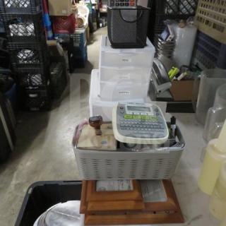 Lot of assorted office supplies including label maker, stapler, storage bins; good condition, ideal for home or office use.