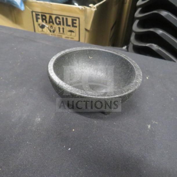 Black molcajete bowl made of stone, circular shape, three small feet, excellent condition, suitable for grinding spices.