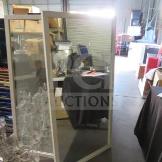Framed mirror, 30x60 inches, in a storage setting. Rectangular with a simple frame, in good condition.