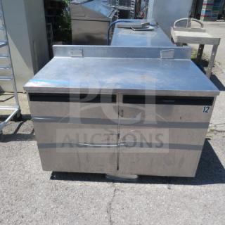 Delfield 2-door worktop cooler on casters, stainless steel, 48x29x36 inches, missing 2 casters, visible scratches and dents.