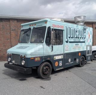 2002 Freightliner MT45 Ludicrous wrapped 18' food truck with propane hookup, grease hood, fryer, griddle, grill, refrigeration, and serving window.