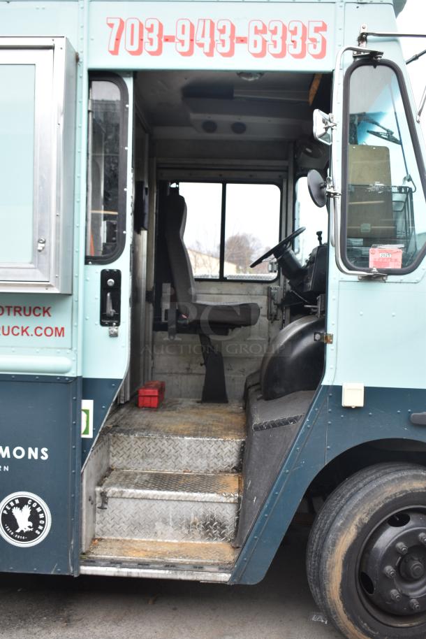 2002 Freightliner MT45 food truck entry view, showing driver's seat, steering wheel, and step interior.