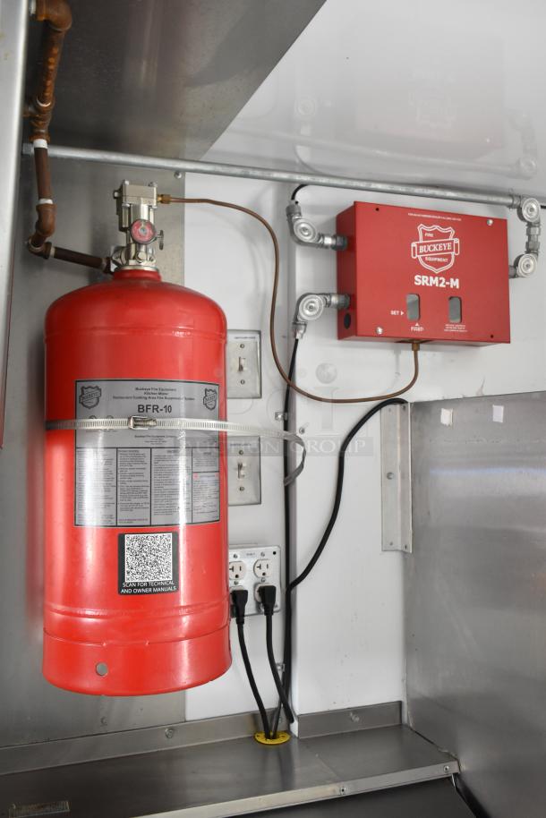 Red Buckeye fire suppression system inside a 2002 Freightliner MT45 food truck, showing tank and control panel.