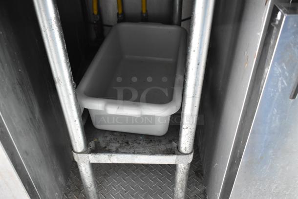 Interior of 2002 Freightliner MT45 food truck showing a white bin on a metal shelf within the propane hookup area.