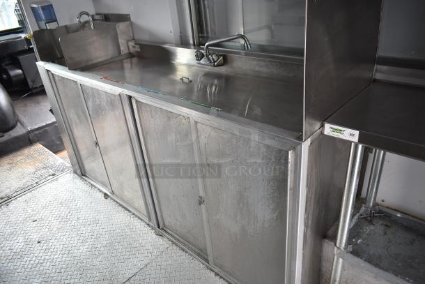Stainless steel food truck interior showing sink and counter space. Regency NSF label visible.