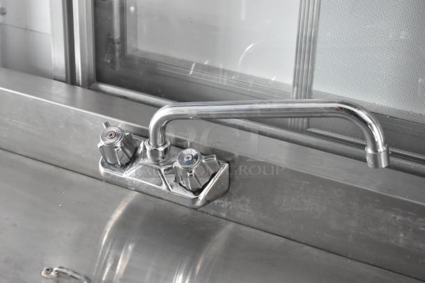 Stainless steel kitchen sink faucet in 2002 Freightliner MT45 food truck, features dual temperature controls.