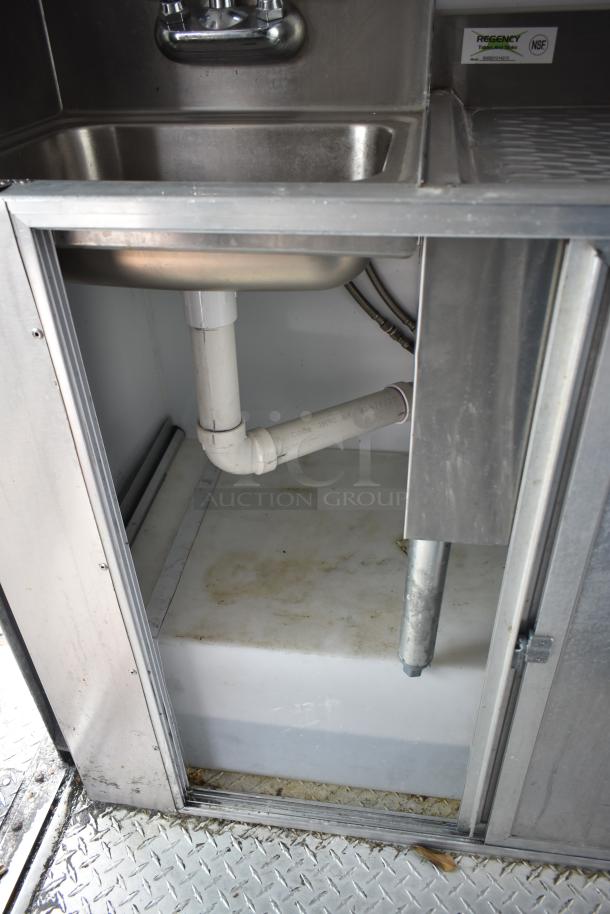 Stainless steel sink and plumbing inside 2002 Freightliner MT45 food truck, featuring Regencey NSF-certified tag.