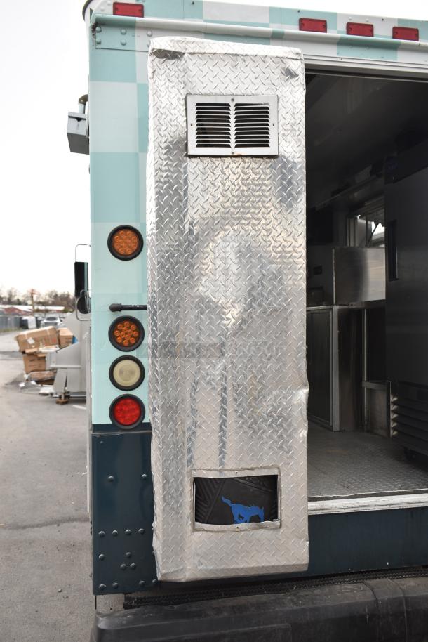 2002 Freightliner MT45 food truck with diamond plate cladding, serving window, and visible kitchen equipment.