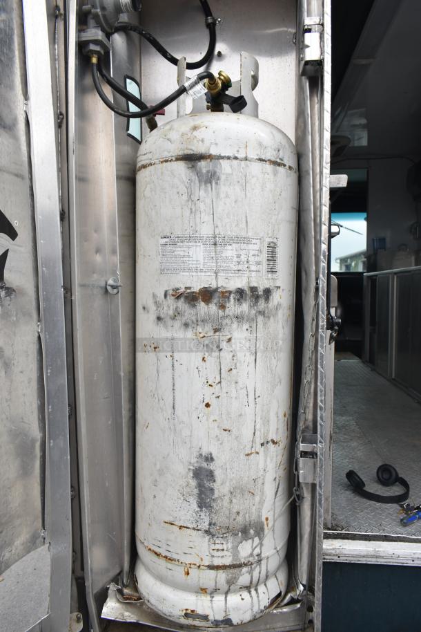 Freightliner MT45 food truck propane hookup, showing attached large propane tank with visible wear and labeling.