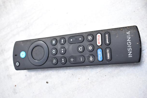 Remote control labeled Insignia with various buttons, including Netflix and Prime Video shortcuts, placed on a light surface.