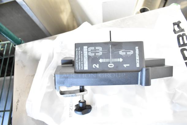 2023 Bizerba GSP HD meat slicer, 120 volts, 1 phase. Includes adjustment clamp. Brand markings visible.