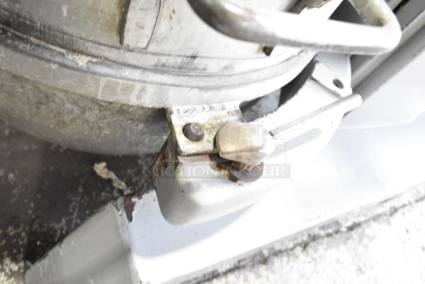 Hobart P660 60-quart planetary dough mixer detail showing attachment area, metal, some signs of wear, and mechanical lever.