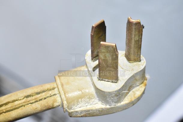 Close-up of a worn, three-prong electrical plug for a Hobart P660 commercial dough mixer.