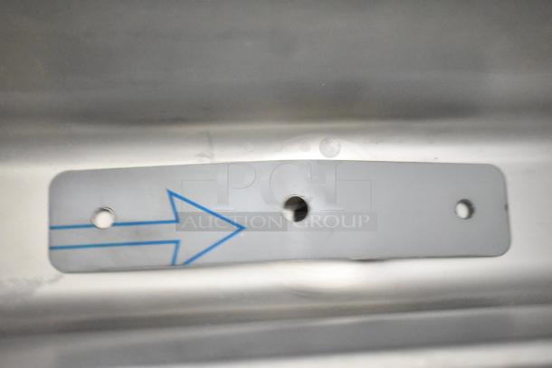 A close-up of a silver metal plate with blue arrow and three circular holes, part of a Frosty Factory 217W machine.