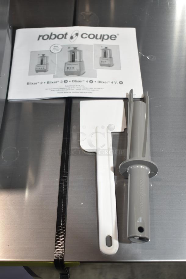 Brand new Robot Coupe Blixer 3 Series D food processor accessories, including manual and tools, on a countertop.