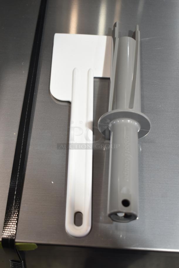 Alt Text: Robot Coupe Blixer 3 Series D accessories, including a white spatula and gray tool, on a metallic surface.