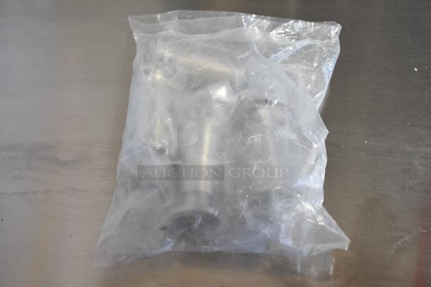 Plastic-wrapped components for Vollrath JW30PA countertop cheese melter, pictured on a metallic surface.