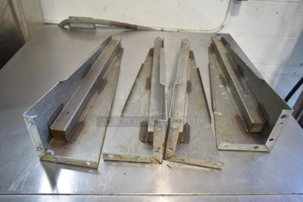 Metal components for a Garland Master 200 Convection Oven, showing wear, laid on a metallic surface.