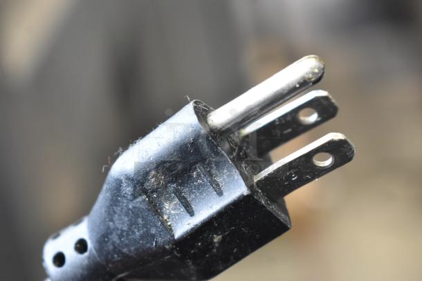 Close-up of a power plug for the 2016 Hobart HTi-7LH Commercial Countertop Food Portioning Scale, showing metal prongs.