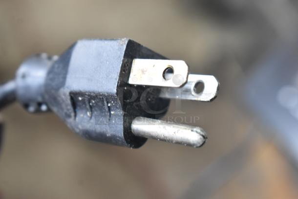 Close-up of a power plug for a 2017 Hobart HTi-7LH26 commercial food portioning scale. Features a three-prong design.