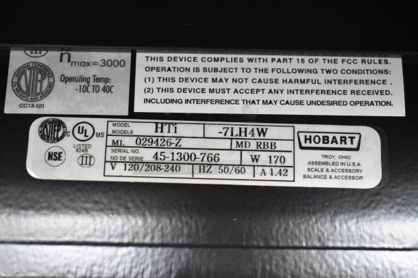 2025 Hobart HTi-7LH4W scale labels showing model, voltage, serial numbers, and compliance details.