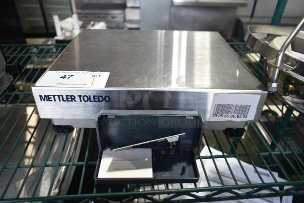 Mettler Toledo BC Countertop Scale, stainless steel, barcode visible, minor wear, open panel showing internal components.