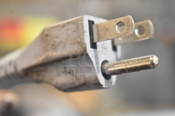 Close-up of a plug from the 2021 Bizerba GSP H Commercial Meat Slicer, showing a three-prong connector with signs of use.