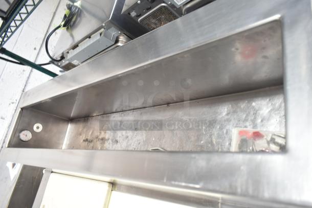 Stainless steel commercial prep table, 115 volts, 1 phase, showing minor wear, with visible gauge inside compartment.