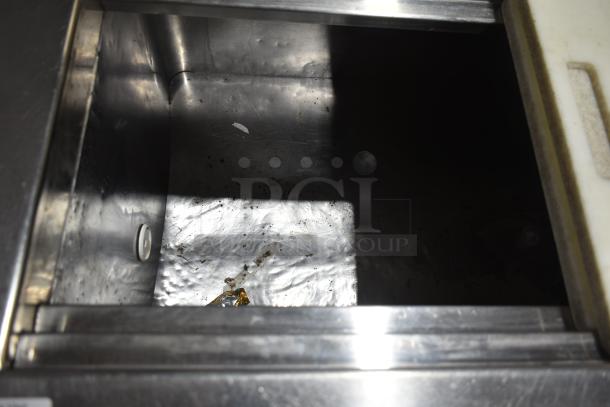 Commercial prep table interior, stainless steel, showing wear. Operates at 115 volts, 1 phase. Ideal for kitchen use.