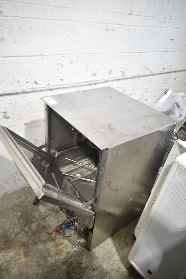 Jackson Avenger undercounter dishwasher, stainless steel, open door, visible internal racks, some wear and wiring exposed.