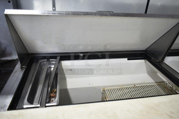 True TSSU-72-30M-B-ST commercial prep table with open lid, showing interior shelves and stainless steel pans. Good condition.