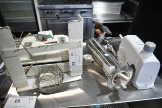 Four items including a beer tower, Ecolab dispenser, fire suppression box, and metal piece on auction. Displayed in used condition.