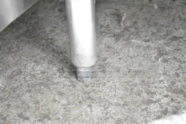 A close-up view of a metal leg on the Commercial 3 Well Steam Table, showing its connection to the concrete floor.