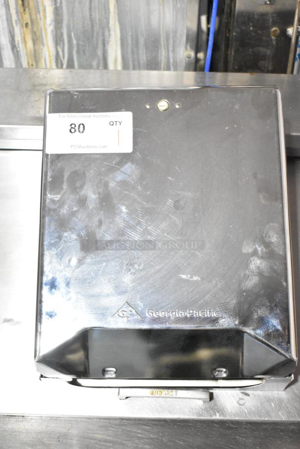 Georgia Pacific dispenser, stainless steel, used condition with visible fingerprints, logo embossed on the front.