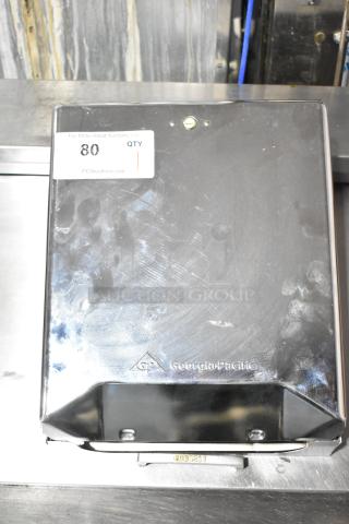 Georgia Pacific dispenser, stainless steel, used condition with visible fingerprints, logo embossed on the front.