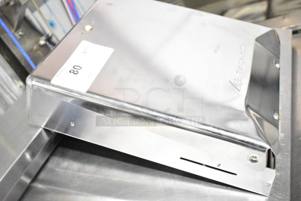 Georgia Pacific stainless steel dispenser, pristine condition, model label visible, secured with screws, slight surface marks.