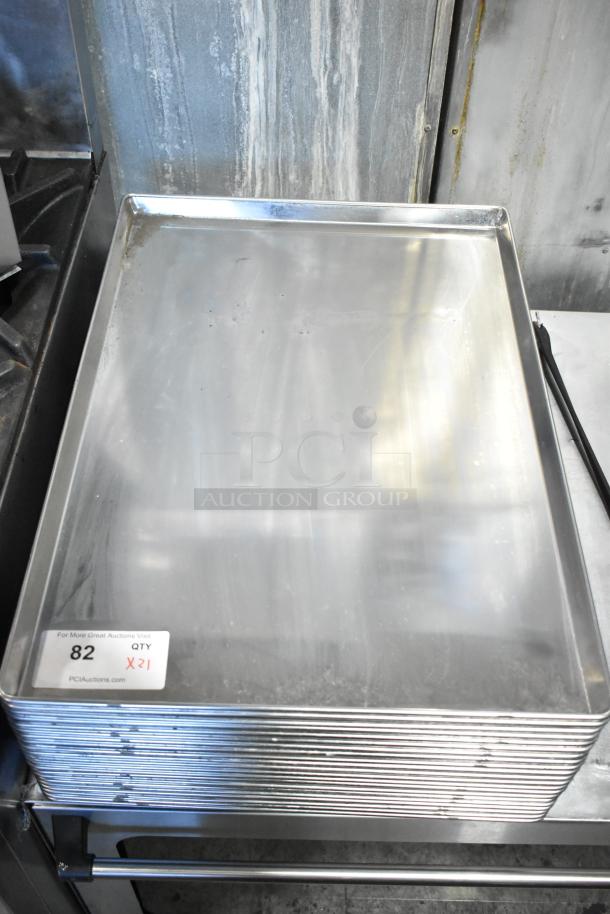 Stack of 21 full-size baking pans, stainless steel, lightly used, auction lot 82, quantity 21 times bid.