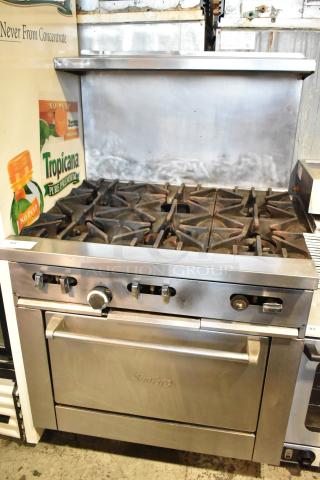 Garland SunFire gas-powered 6-burner range with oven, over shelf, backsplash, and commercial casters in good condition.