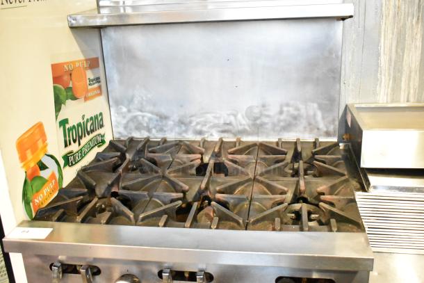 Garland SunFire gas-powered 6-burner range with oven, over shelf, and backsplash on commercial casters.