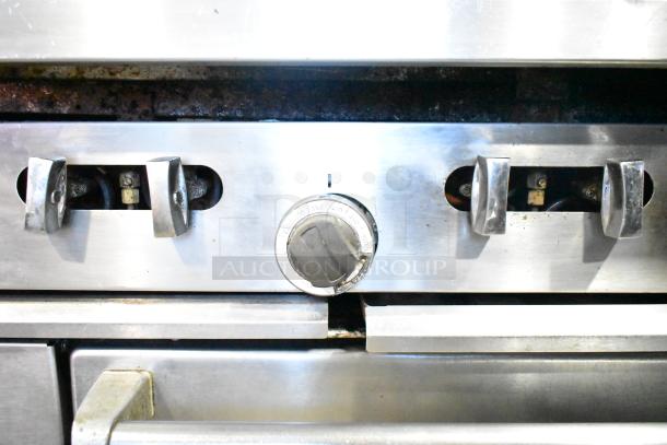 Garland SunFire commercial gas range controls, stainless steel finish, part of a 6-burner range with oven, overshelf, and casters.